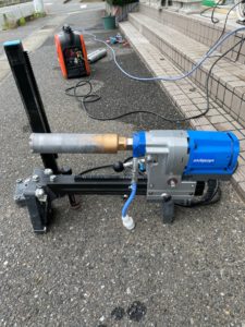 フェンス支柱施工のため土間に穴をあける機械